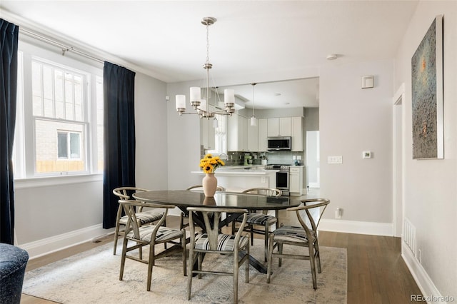 dining area with an inviting chandelier and light hardwood / wood-style floors