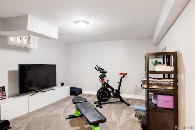 exercise area with carpet floors and a textured ceiling