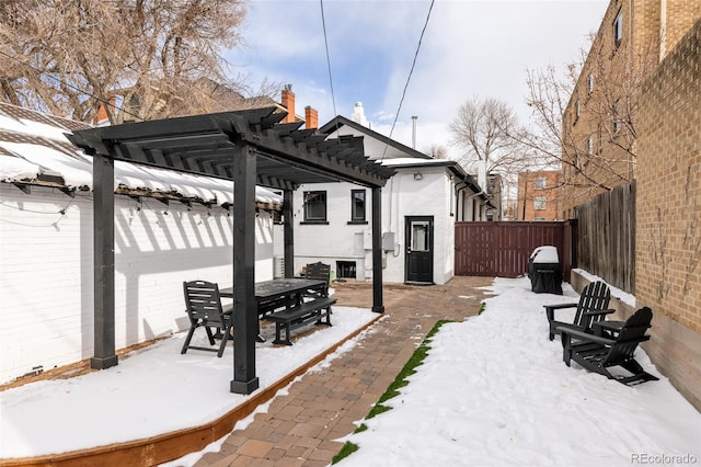 snow covered patio with a pergola