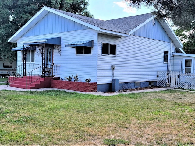 view of front of home featuring a shingled roof and a front yard