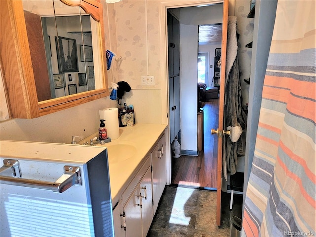 bathroom with vanity and wallpapered walls