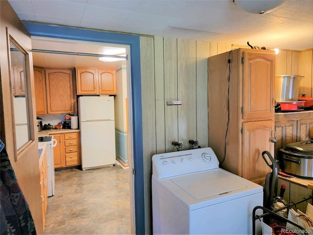 laundry area with washer / clothes dryer, wood walls, and light floors