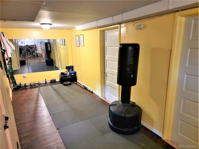 exercise room featuring wood finished floors and baseboards