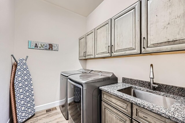 4536 Shady Path Ln, Castle Rock, CO 80104 - laundry room featuring cabinet space, washer and dryer, light wood finished floors, and baseboards