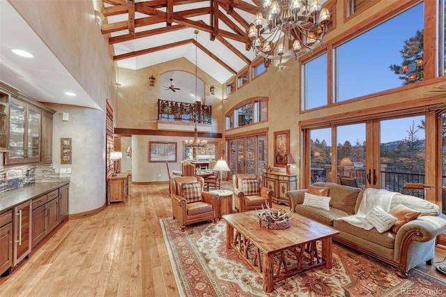 living room featuring high vaulted ceiling, beamed ceiling, a chandelier, light wood-type flooring, and french doors