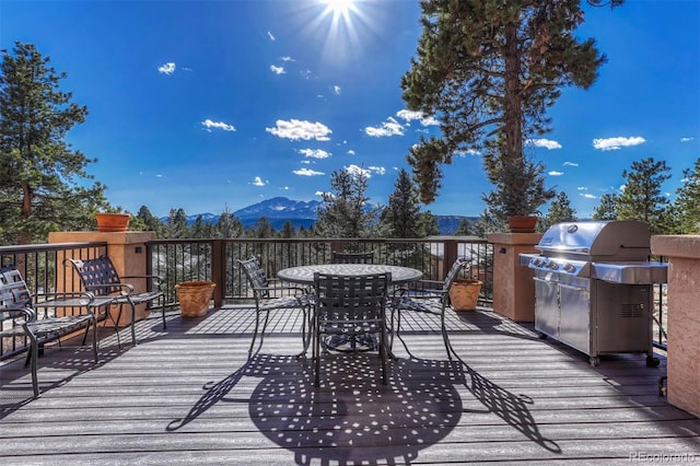 wooden terrace with a mountain view and a grill