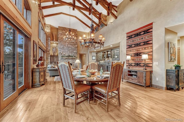 dining space featuring beamed ceiling, high vaulted ceiling, a chandelier, and light hardwood / wood-style floors