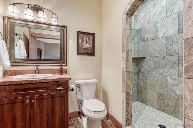 bathroom featuring vanity, toilet, and tiled shower