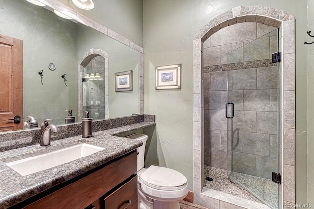 bathroom featuring an enclosed shower, vanity, and toilet