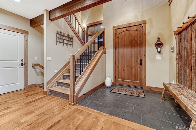 foyer featuring dark wood-type flooring and beamed ceiling