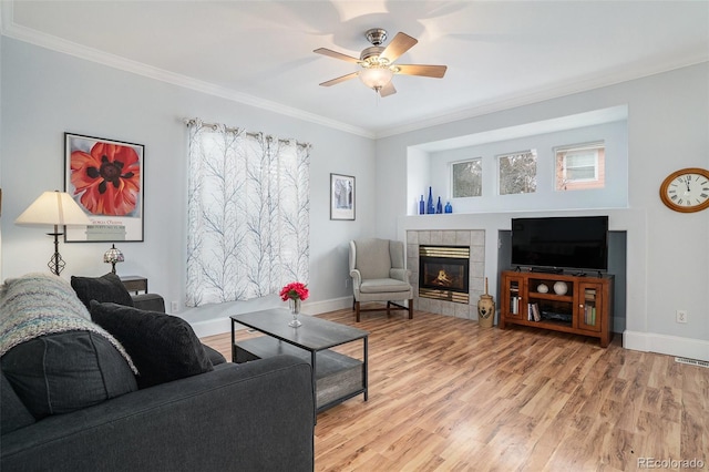 living room with a fireplace, light hardwood / wood-style flooring, and ornamental molding