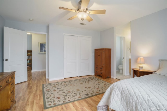 bedroom featuring ensuite bath, light hardwood / wood-style flooring, ceiling fan, and a closet