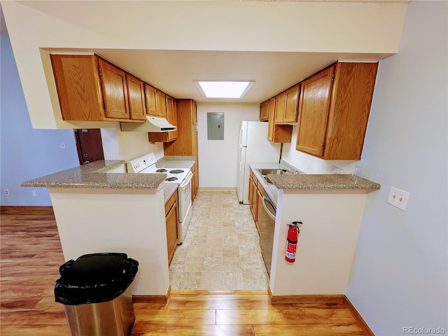 kitchen featuring white appliances, light countertops, a peninsula, and electric panel