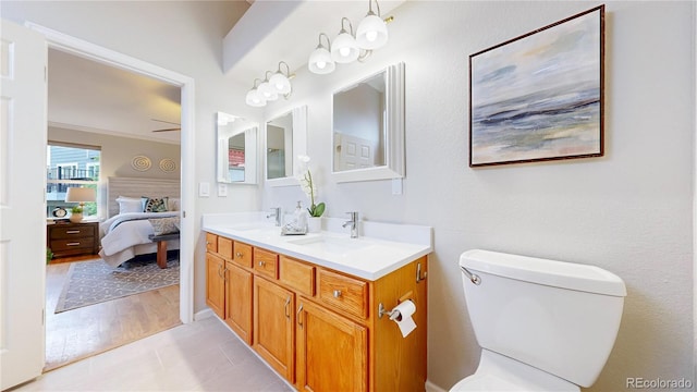 1229 Berganot Trl, Castle Pines, CO 80108 - ensuite bathroom with double vanity, toilet, a ceiling fan, and tile patterned flooring