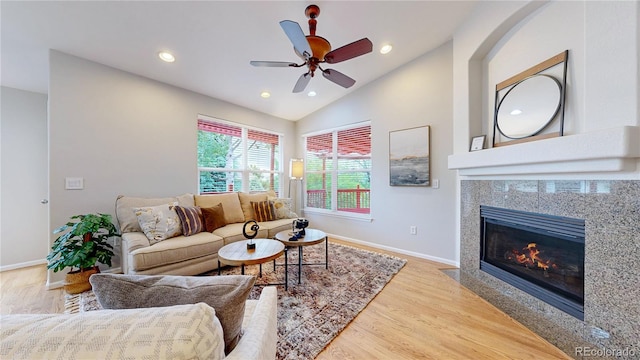 1229 Berganot Trl, Castle Pines, CO 80108 - living room with vaulted ceiling, a tiled fireplace, wood finished floors, baseboards, and recessed lighting