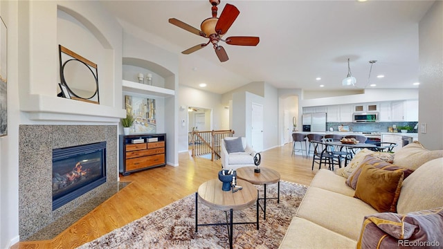 1229 Berganot Trl, Castle Pines, CO 80108 - living area with light wood-style flooring, lofted ceiling, ceiling fan, recessed lighting, and a high end fireplace