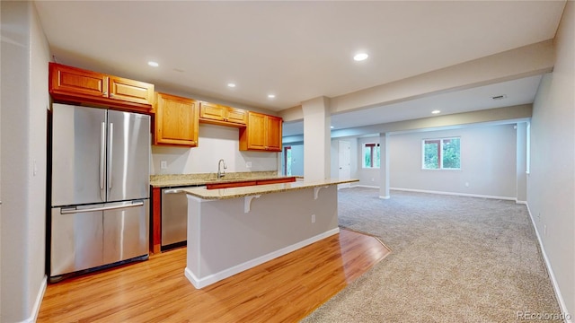 1229 Berganot Trl, Castle Pines, CO 80108 - kitchen with stainless steel appliances, baseboards, a breakfast bar, recessed lighting, and a kitchen island