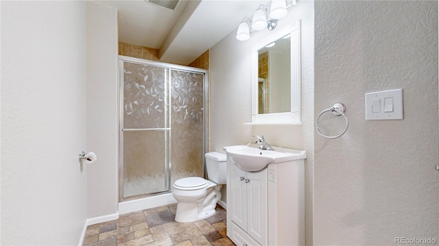 1229 Berganot Trl, Castle Pines, CO 80108 - full bathroom with stone finish floors, vanity, toilet, a shower stall, and a textured wall