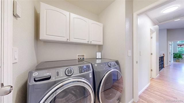 1229 Berganot Trl, Castle Pines, CO 80108 - laundry area featuring washer and dryer, cabinet space, light wood-type flooring, and baseboards