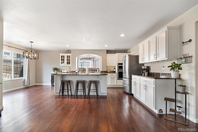 11885 Helena St, Commerce City, CO 80022 - kitchen featuring white cabinetry, a breakfast bar area, and an island with sink