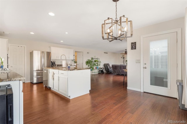 11885 Helena St, Commerce City, CO 80022 - kitchen featuring white cabinetry, stainless steel appliances, hanging light fixtures, and dark stone counters