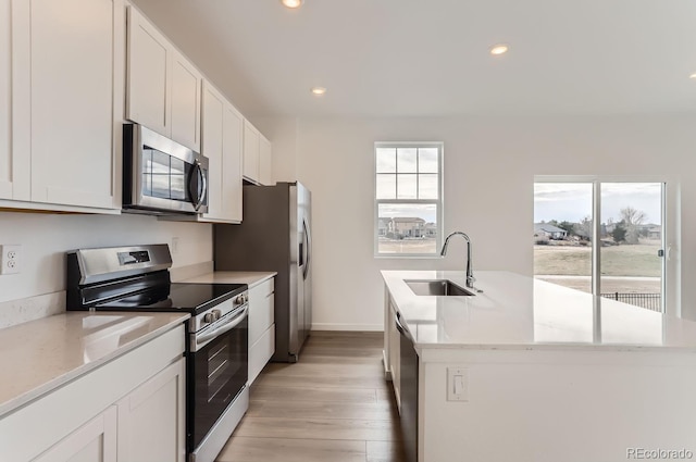 kitchen featuring white cabinetry, sink, an island with sink, and appliances with stainless steel finishes