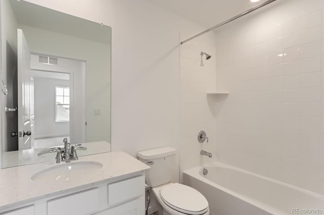 full bathroom featuring tiled shower / bath, vanity, and toilet