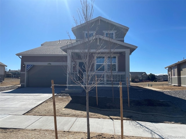 view of front of property featuring an attached garage, a shingled roof, and concrete driveway