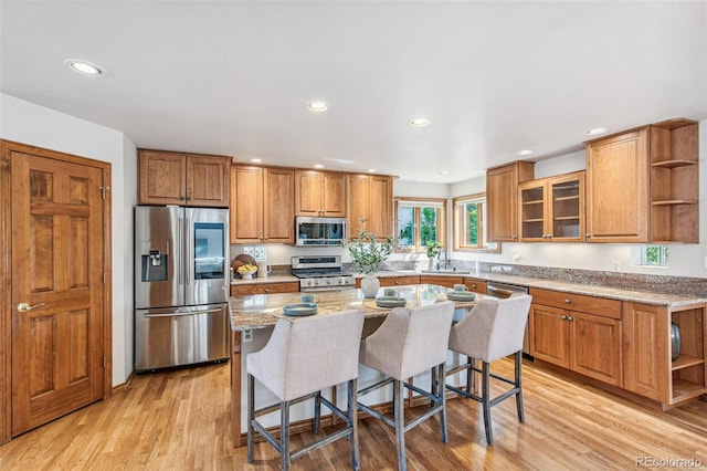 942 Xenon Ct, Golden, CO 80401 - kitchen with appliances with stainless steel finishes, open shelves, brown cabinets, a breakfast bar, and recessed lighting