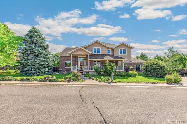 942 Xenon Ct, Golden, CO 80401 - view of front of house with brick siding, a porch, and a front lawn