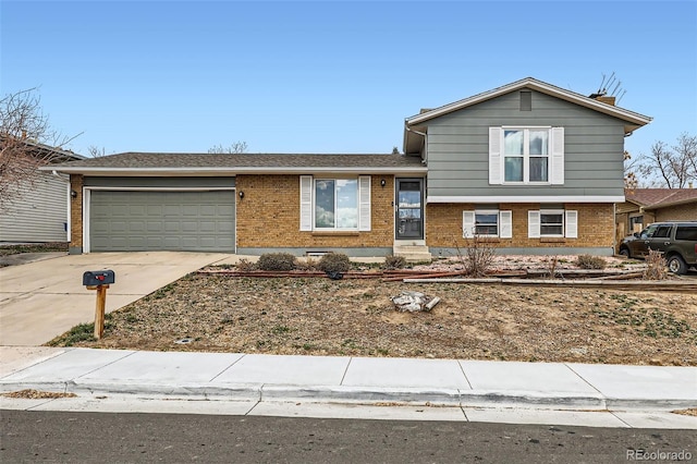 split level home with brick siding, a garage, and concrete driveway