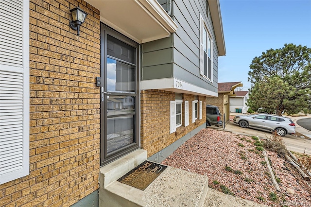property entrance featuring brick siding