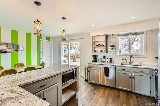 kitchen with stainless steel appliances, gray cabinetry, a sink, and open shelves