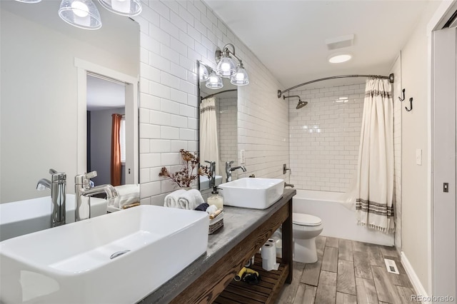 bathroom featuring shower / bath combination with curtain, tile walls, a sink, and wood finished floors