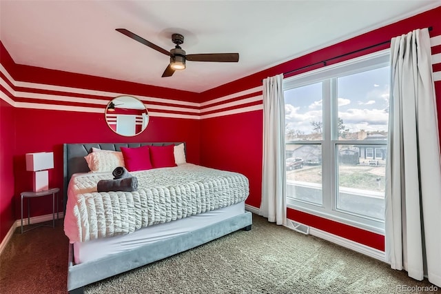 bedroom featuring baseboards, a ceiling fan, carpet floors, an accent wall, and visible vents