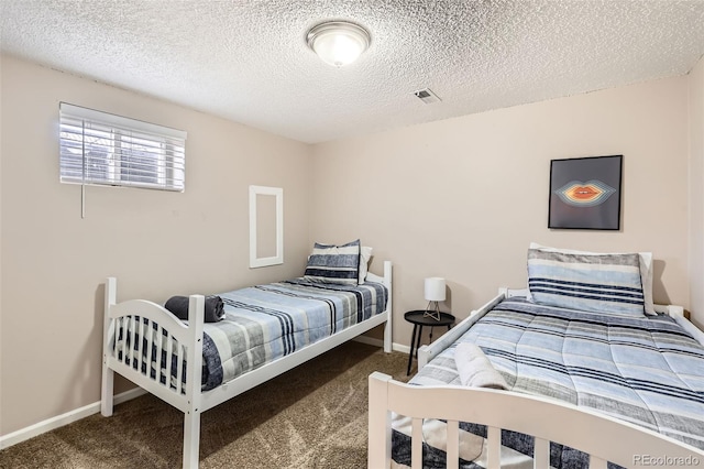 carpeted bedroom with a textured ceiling, baseboards, and visible vents