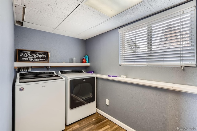washroom with baseboards, a textured wall, independent washer and dryer, laundry area, and wood finished floors