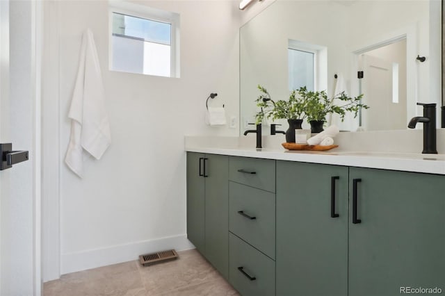 full bathroom featuring double vanity, visible vents, baseboards, and a sink