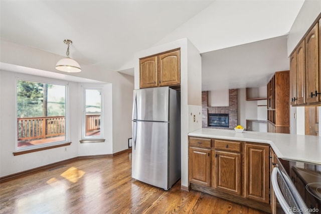 kitchen featuring appliances with stainless steel finishes, light countertops, and brown cabinetry