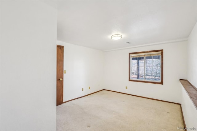 carpeted spare room with visible vents and baseboards