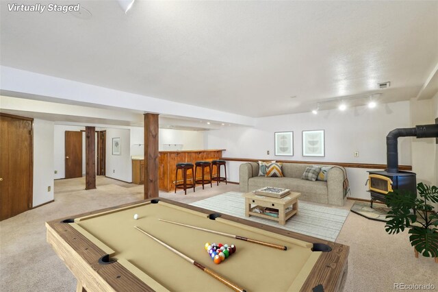 game room featuring a dry bar, light colored carpet, pool table, a wood stove, and track lighting