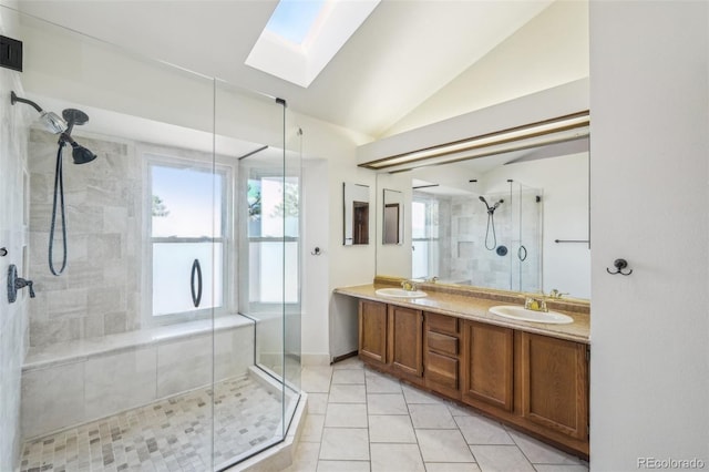 bathroom with a stall shower, vaulted ceiling with skylight, and a sink