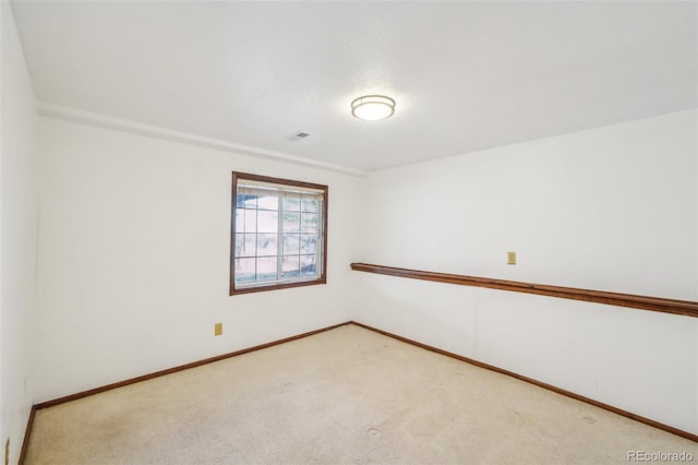 carpeted spare room featuring visible vents and baseboards