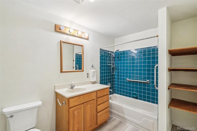 bathroom with toilet, washtub / shower combination, wood finished floors, and vanity