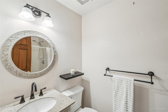 full bath with toilet, vanity, walk in shower, and visible vents