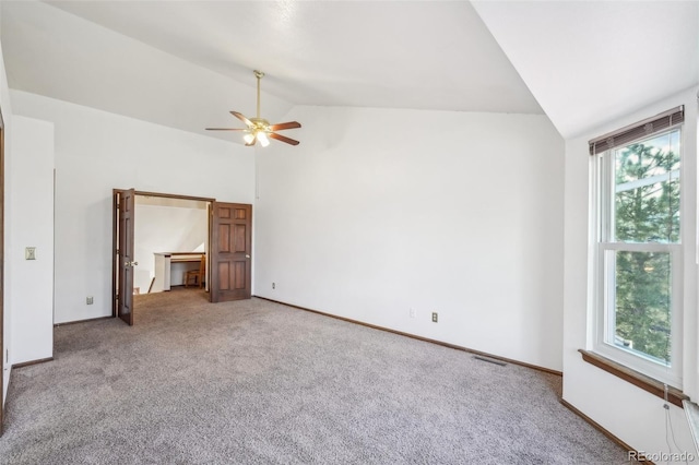 unfurnished bedroom featuring carpet flooring, a ceiling fan, visible vents, vaulted ceiling, and baseboards