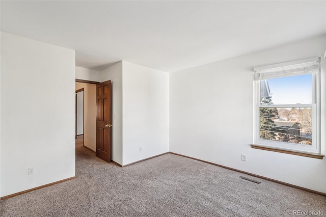 unfurnished room with carpet, baseboards, and visible vents