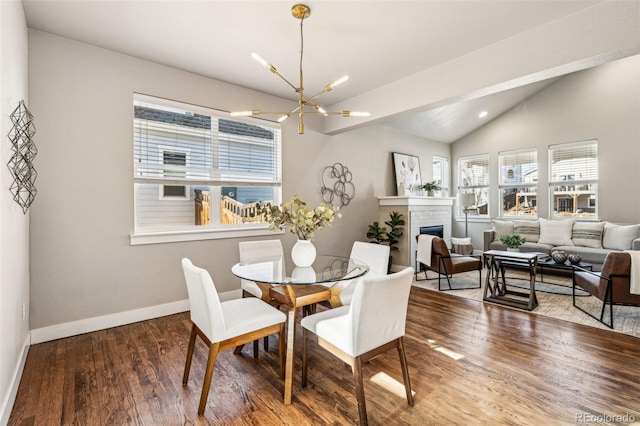 dining area with lofted ceiling, hardwood / wood-style floors, and a notable chandelier