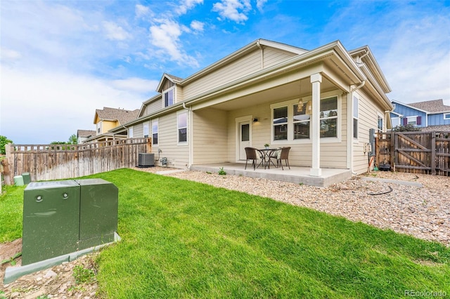 back of property with cooling unit, a yard, and a patio area