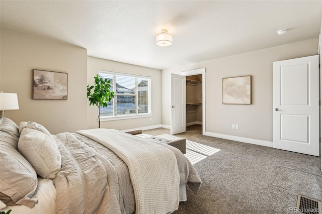 carpeted bedroom with a closet, a spacious closet, and a textured ceiling